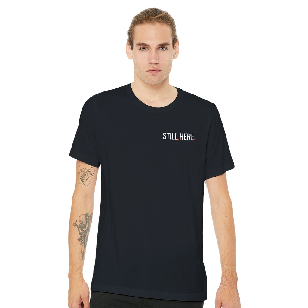 Man wearing a black t-shirt with 'STILL HERE' text on a white background
