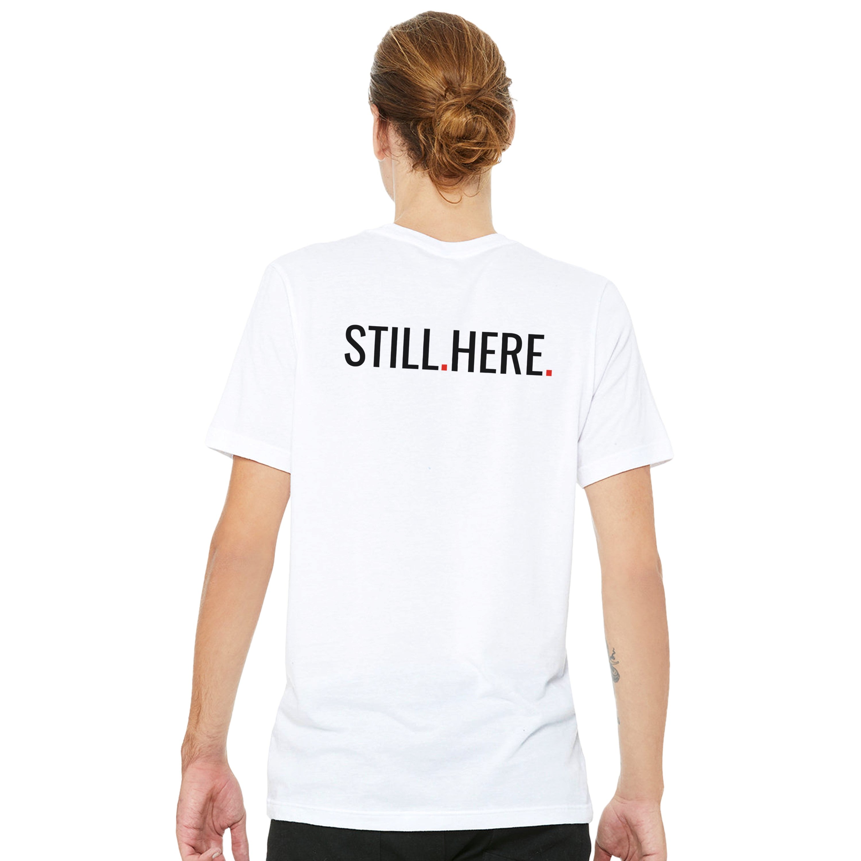 Person wearing a white t-shirt with 'STILL HERE' text on the back, standing against a white background